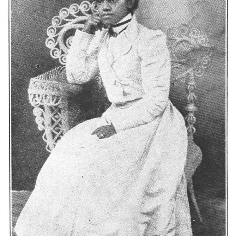 Public domain photo of Effie Waller Smith in a white dress, seated with one hand near her mouth and the other hand on her lap.